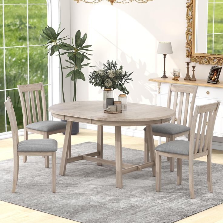 a dining table with four chairs and a potted plant