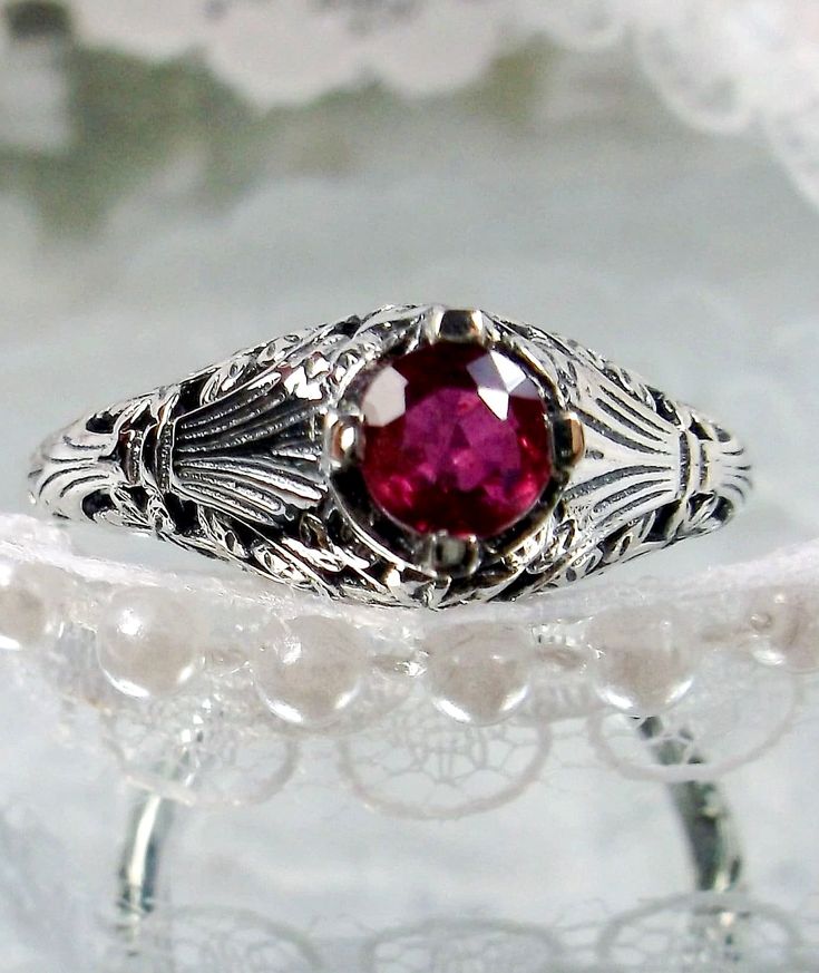 <> Made To Order This is a Victorian/Edwardian reproduction ring in sterling silver (Solid 10K and 14K gold option also now available) filigree with a natural red ruby gemstone solitaire. This full cut round cut red ruby gemstone is 4mm in diameter. The inside of the band is marked 925 for sterling (or 10K/14K if gold option selected). Notice the beautiful floral design of the filigree setting and band. This is a lovely rendition of an Antique filigree ring. A gift ring box is included and all r Antique Sterling Silver Engraved Ring With Intricate Design, Antique Engraved Ring With Intricate Design In Sterling Silver, Victorian Engraved Rings For Marriage, Vintage Ceremonial Engraved Ring With Intricate Design, Vintage Sterling Silver Filigree Ring With Intricate Design, Victorian Ruby Ring With Center Stone, Ceremonial Heirloom Oval Ruby Ring, Ruby Filigree Wedding Ring, Red Victorian Filigree Ring For Anniversary