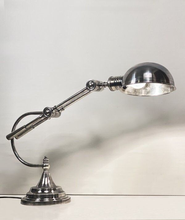 an old fashioned desk lamp on a white table