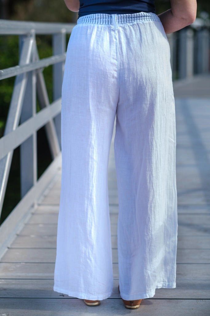 Sail through the warm weather in style! Product Description: Get ready to set sail in style with our Cordelia White Sailor Pant! Made from breezy linen, these wide leg pants feature convenient patch pockets and charming belt details. They're the perfect addition to your vacation wardrobe, but also a must-have for those warmer days at home. No need for accessories, these pants are a statement piece on their own! Fit: Flattering Wide Leg Fun Belt Detail Front Patch Pockets Inseam Approximately 28. White Linen Wide Leg Pants For Vacation, White Linen Wide Leg Vacation Pants, White Linen Pants For The Beach, White Linen Pants For Beach, Chic Linen Pants For Beach, Chic Linen Beach Pants, White Linen Bottoms For Vacation, Vacation Linen Wide-leg Bottoms, Linen Wide-leg Pants For The Beach