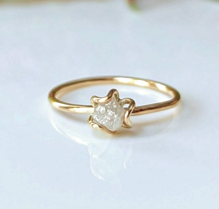 a gold ring with a white diamond on it