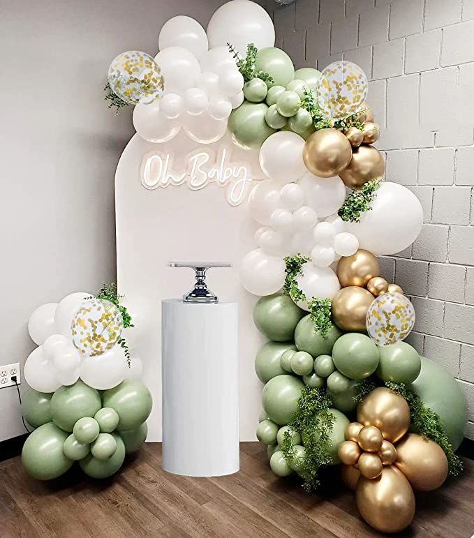 balloons and greenery decorate the backdrop for an event