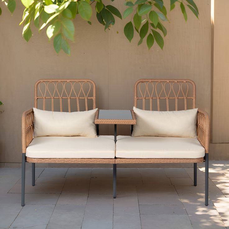 two wicker couches sitting next to each other with pillows on top of them