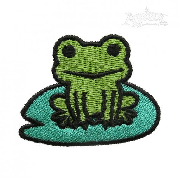 a green frog sitting on top of a blue pillow with the words frog in it's mouth