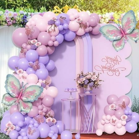 a birthday party with balloons and flowers on the wall, decorated in pastel colors