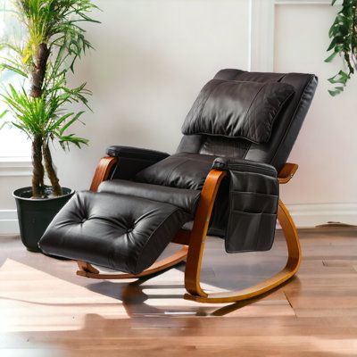 a black recliner chair sitting in front of a potted plant