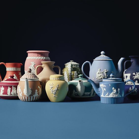 a group of vases sitting next to each other on a blue tableclothed surface