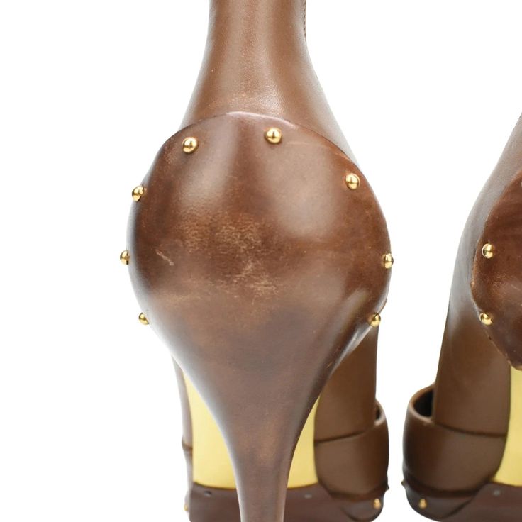 Gucci pointed-toe pumps in brown with over-exaggerated heel tabs. Features gold studs along the heel and toe sole and gold sole. Brand = Gucci Condition = 8/10, Very good, scuffing to heels and toes Size = Women's 8 US Heel Height = 110mm Material = Leather Hardware = Gold SKU = 3036-8 Studded Fitted Heels For Formal Occasions, Formal Studded Fitted Heels, Formal Fitted Studded Heels, Gucci Leather Heels With Sculpted Heel, Fitted Pointed Toe Heels With Studs, Gucci Round Toe Office Heels, Gucci Round Toe Heels For Office, Gold Pointed Toe Heels With Leather Sole, Elegant Gold Heels With Studs