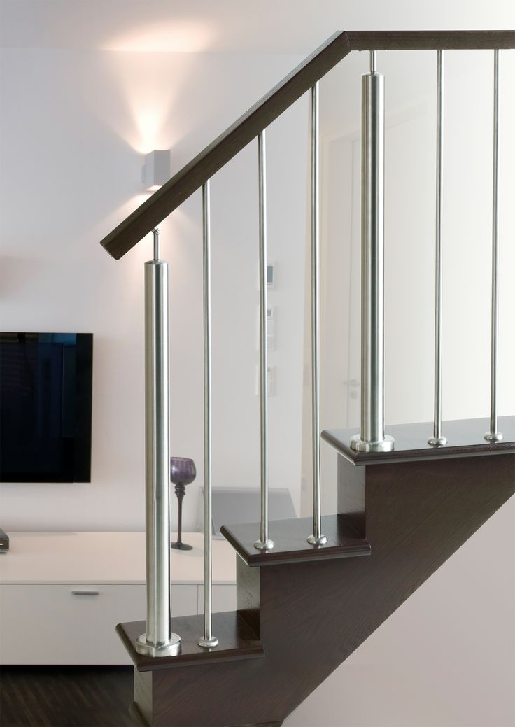 there is a television on the wall in this living room, and stairs lead up to it