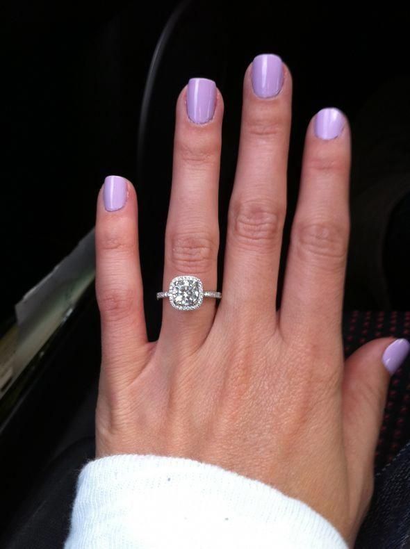 a woman's hand with a purple manicure and a diamond ring on it