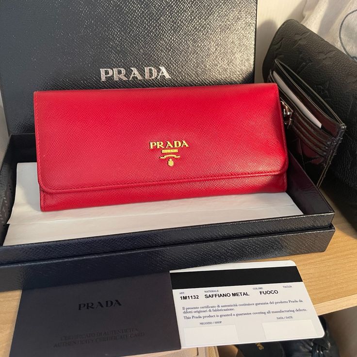 This Red Prada Wallet Is In Brand New Condition, Received As A Gift Many Years Ago And Sitting In Closet, Unused. It Comes With All Original Packaging, Prada Shopping Bag, Box, Authenticity Card. Brand New Is Over $960 With Tax. Snap Closure Metal Lettering Logo Two Bill Compartments Ten Card Slots Four Interior Pockets Internal Coin Pocket With Zipper External Coin Pocket With Zippe Height: 9.5cm Width: 18.7cm Link The Prada Site For More Details On This Wallet: Https://Www.Prada.Com/Us/En/Wome Prada Wallet Aesthetic, Designer Red Wallet With Interior Card Slots, Designer Red Wallets With Interior Card Slots, Luxury Red Wallets With Interior Card Slots, Luxury Red Bifold Wallet, Red Rectangular Wallet, Luxury Red Wallet With Original Box, Designer Red Wallet For Travel, Luxury Red Leather Wallet