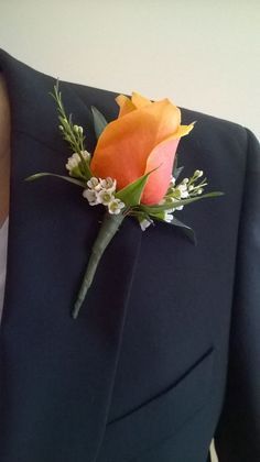 a man in a suit with a boutonniere on his lapel flower