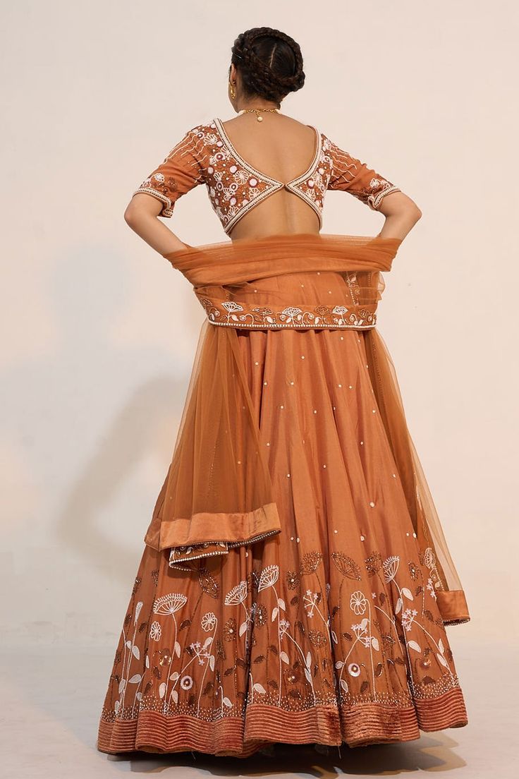 Ochre brown lehenga, accentuated with floral embroidery in cutdana and sequin embellishments. Paired with a half sleeve, sweetheart neckline blouse, highlighted with pearl, cutdana and sequin embellishments in floral pattern. Comes with a floral embroidered border dupatta.
Component: 3
Pattern: Embroidery,Embellished
Type Of Work: Floral,Pearl,Sequin,Cutdana
Neckline: Sweetheart Neck
Sleeve Type: Half Sleeves
Fabric: Silk, Organza
Color: Brown
Other Details: 
Floral embroidered waistband
Fabric Brown Resham Embroidered Sets For Diwali, Brown Sets With Resham Embroidery For Diwali, Brown Resham Embroidery Sets For Diwali, Festive Brown Lehenga With Traditional Drape, Designer Wear Sets With Resham Embroidery In Brown, Brown Dupatta With Resham Embroidery For Navratri, Festive Brown Lehenga With Dupatta, Brown Lehenga With Dupatta For Wedding, Brown Wedding Lehenga With Traditional Drape