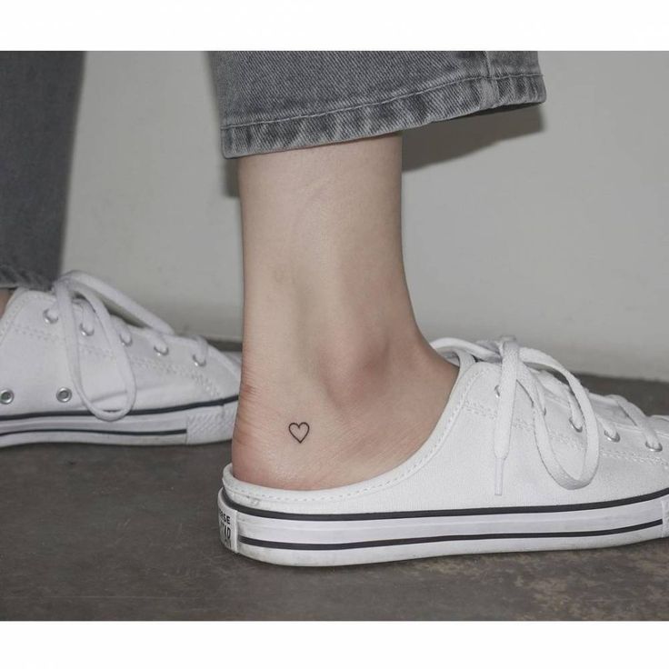 a woman's foot with a small heart tattoo on her left ankle and bottom