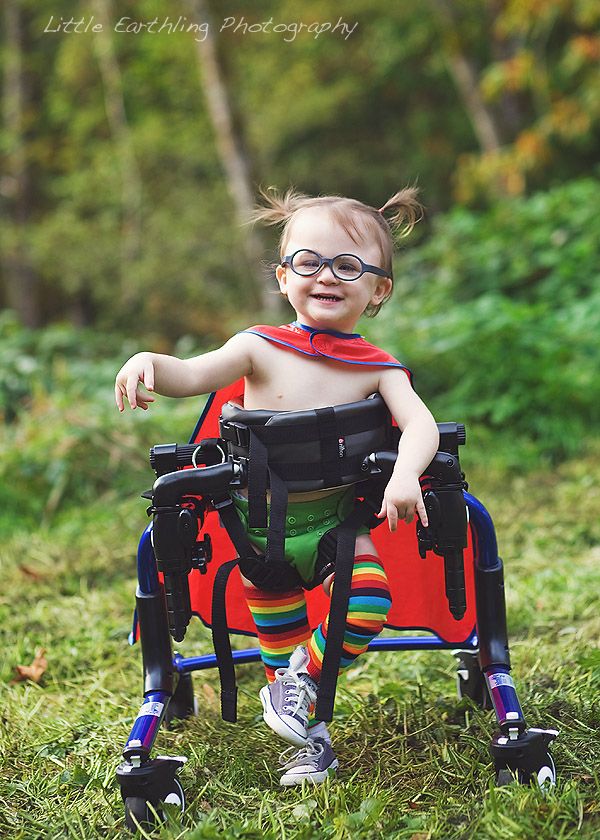 a young child in a red and black wheelchair