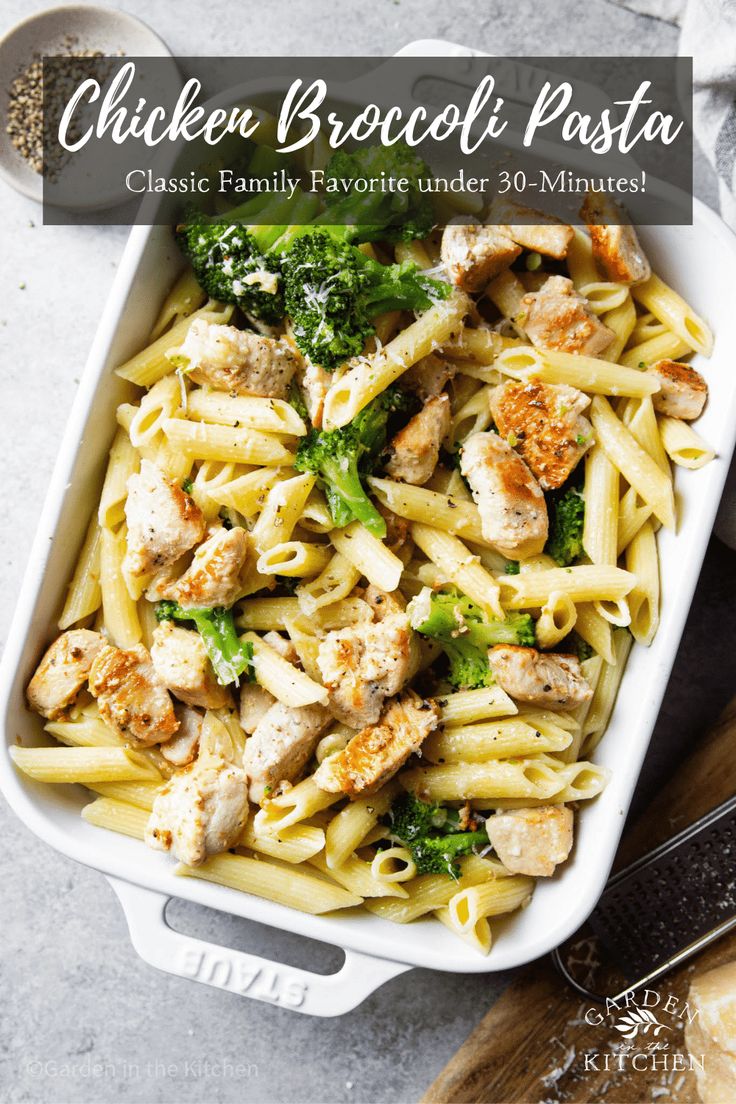 chicken broccoli pasta in a white casserole dish with parmesan cheese