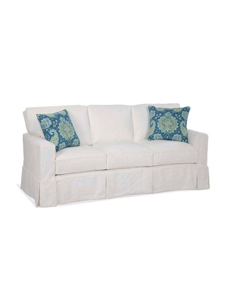 a white couch with blue and green pillows on it's back end, against a white background