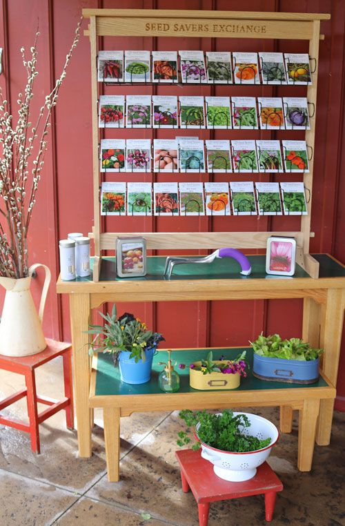 an outdoor garden stand with plants and seed packets