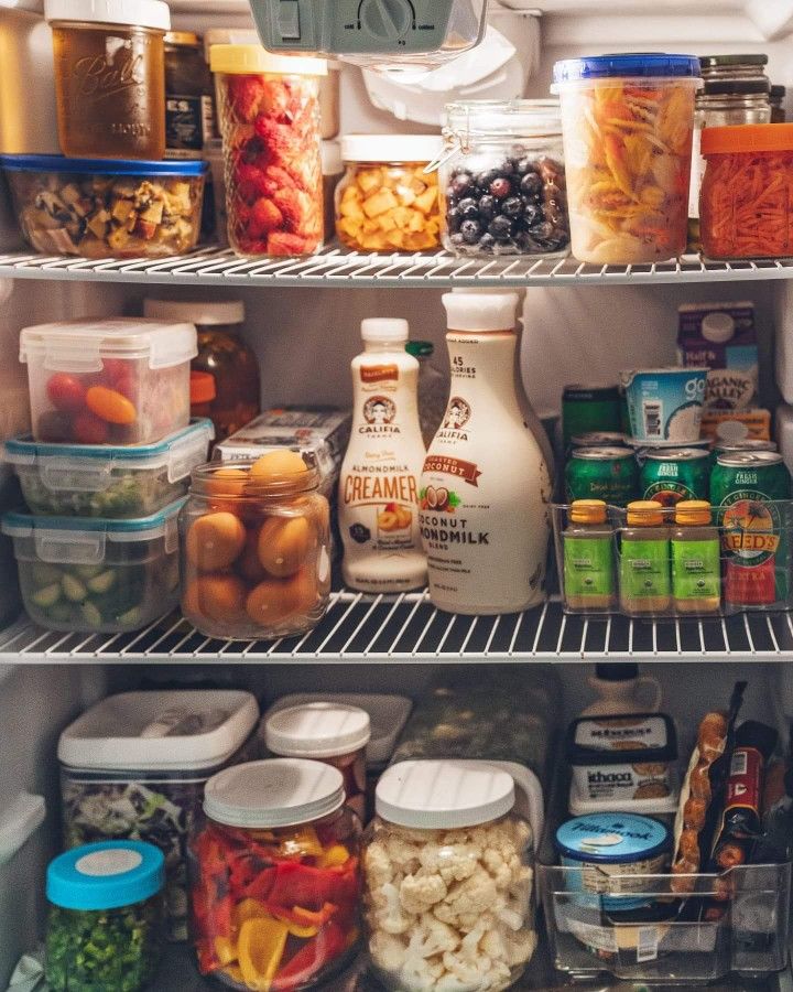 an open refrigerator filled with lots of food and condiments on the bottom shelf