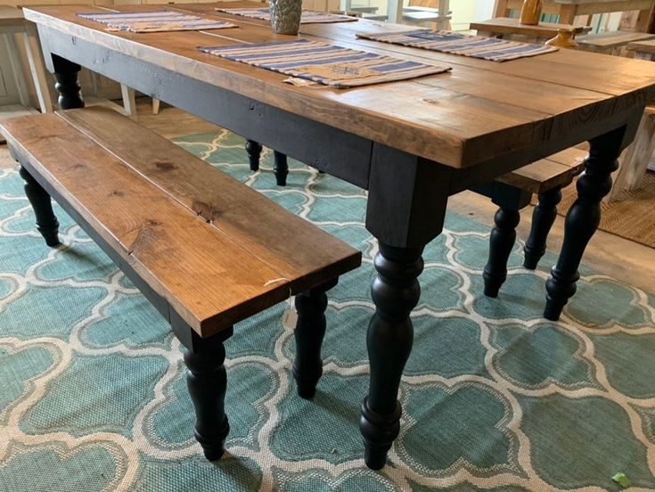 a wooden table with two benches in front of it on top of a blue rug