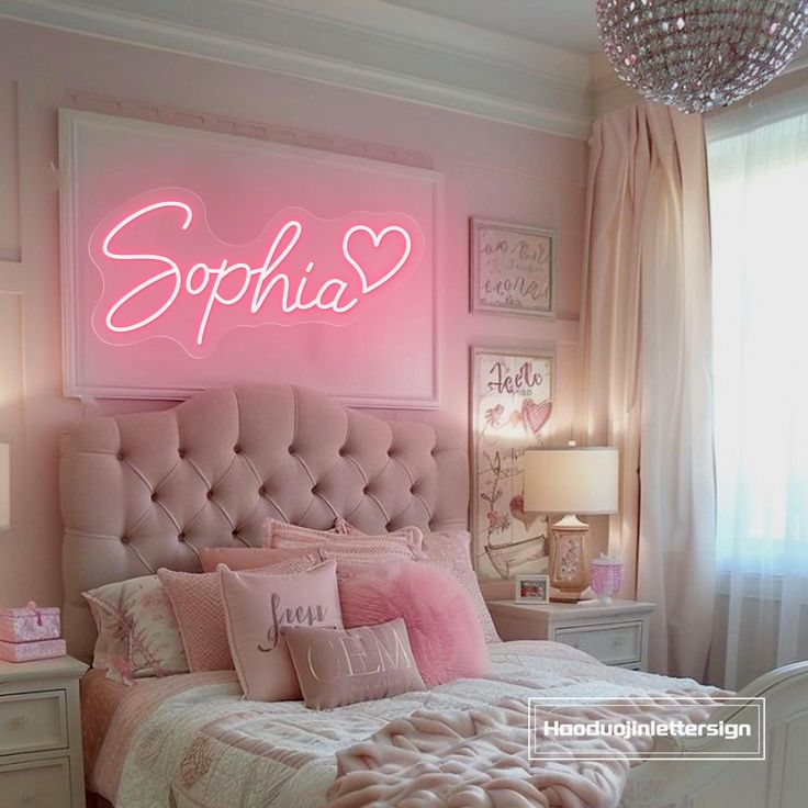 a bedroom with pink walls and white bedding has a neon sign above the headboard