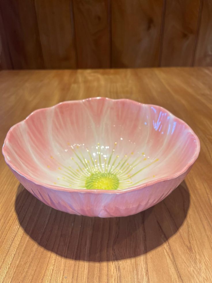 a pink bowl sitting on top of a wooden table