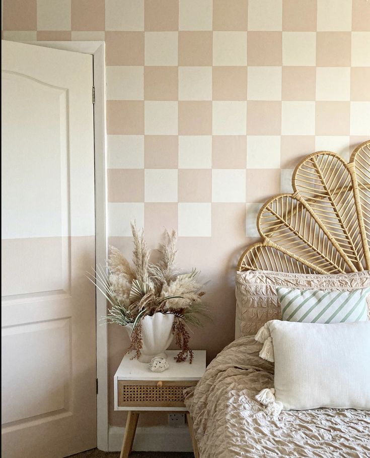 a bedroom with a wicker headboard and decorative wallpaper on the walls behind it