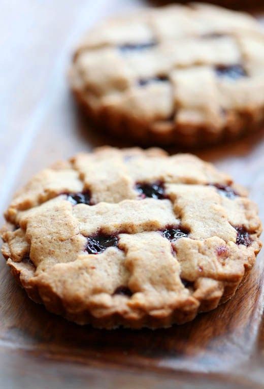 three cookies sitting on top of a wooden table next to each other with blueberries in the middle