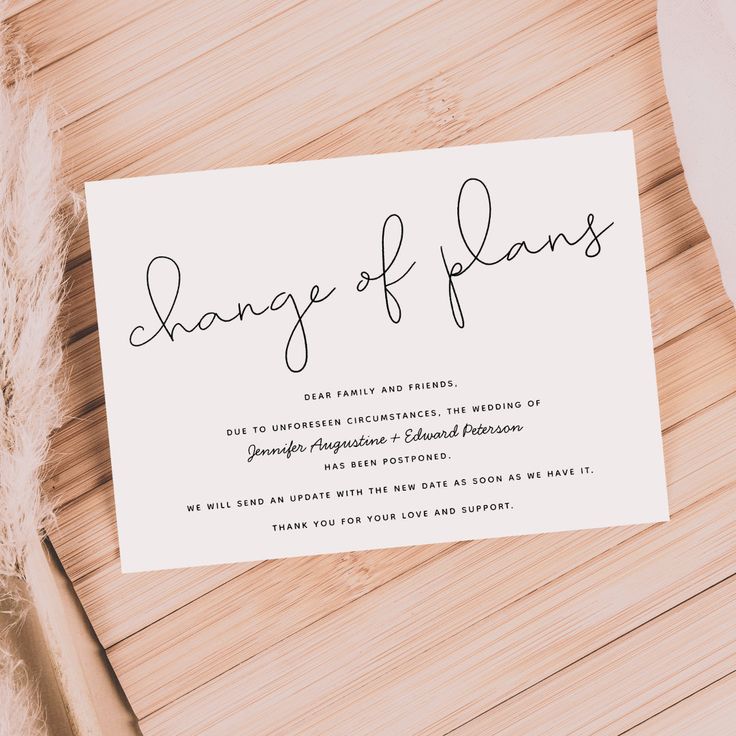 a white card with the word change of plans on it sitting next to some feathers