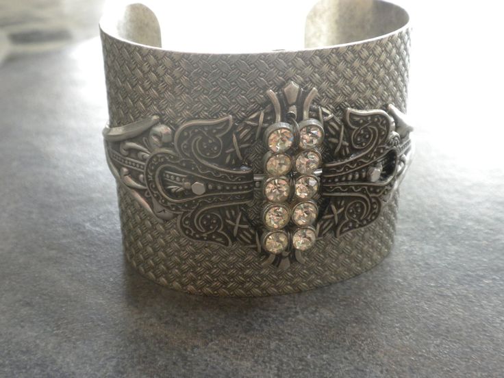 This cocktail bracelet for women is a bangle cuff with rhinestones and is beautiful Art Deco Jewelry. It is adorned with a silver plated brass stamping, a sparkly rhinestone bar. The cuff bracelet is heavy and etched with basket weave designs. The pieces are bolted together securely, and the rhinestone bar is affixed securely with wire in between so it has a 3 dimensional aspect to it. This will adjust to many wrist sizes, although best suited for a medium sized wrist. It is 2 inches wide, and m Silver Bling Cuff Bracelet For Evening, Glamorous Silver Cuff Bracelet With Rhinestones, Glamorous Rhinestone Cuff Bangle Bracelet, Glamorous Adjustable Cuff Bracelet Gift, Glamorous Adjustable Cuff Bracelet As Gift, Silver Bedazzled Jewelry Gift, Silver Bedazzled Jewelry For Gift, Silver Bedazzled Jewelry As Gift, Jeweled Bangle Cuff Bracelet For Party