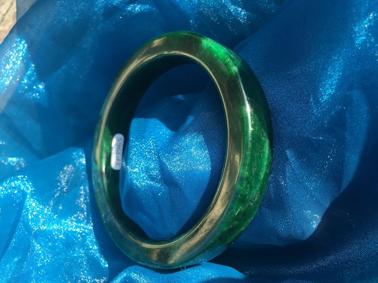 62.44mm Thick Jadeite Green Uncarved Heavy Jade Bangle #965 Dimensions:  62.44mm x 12.32mm x 8.87mm This is a heavier bangle of the type usually used in carving styles.  It has a dense spinach, deep forest green, is really nice. We tested this piece, and it tested as jadeite jade.  The photo here coincides with testing this bangle, but does not come with a professional gem certificate. Please ask questions prior to purchase for best experience and results. Carved Green Jade Bangle, Green Bangle For Collectible Jewelry, Green Bangle Collectible Jewelry, Green Bangle Jewelry Collectible, Green Carved Bangle Bracelet, Green Carved Bangle Bracelets, Green Carved Bracelet As A Gift, Green Carved Bracelets As Gift, Elegant Carved Green Bangle