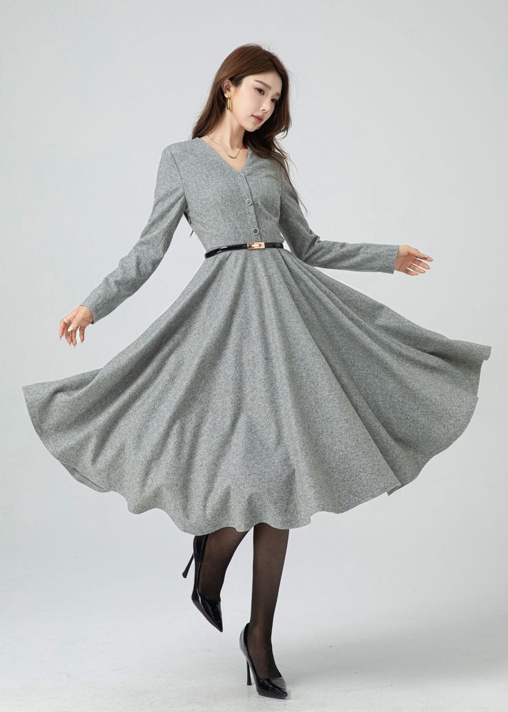 Stay stylishly snug this winter with a light grey wool swing dress. This dress is cinched at the waist with a hemline that can also be turned up beautifully, and has a buttoned front to accent the v-neck. Pair this dress with heeled ankle boots for a sophisticated look. Details: * 30% wool, 30% fiber, 40% polyester * fully satiny lining, more nice to the touch body * V neckline dress * Long sleeves dress * Two side seam pockets * Right zipper closure * Button front * Fit and flare dress * Midi w Gray A-line Winter Dresses, Classic V-neck Winter Dress, Knee-length Buttoned Midi Dress For Winter, Winter Knee-length Midi Dress With Buttons, Gray Knee-length Winter Dress, Winter A-line Midi Dress With Buttons, Chic Gray Winter Dress, Gray Fitted Winter Midi Dress, Fitted Gray Midi Dress For Winter