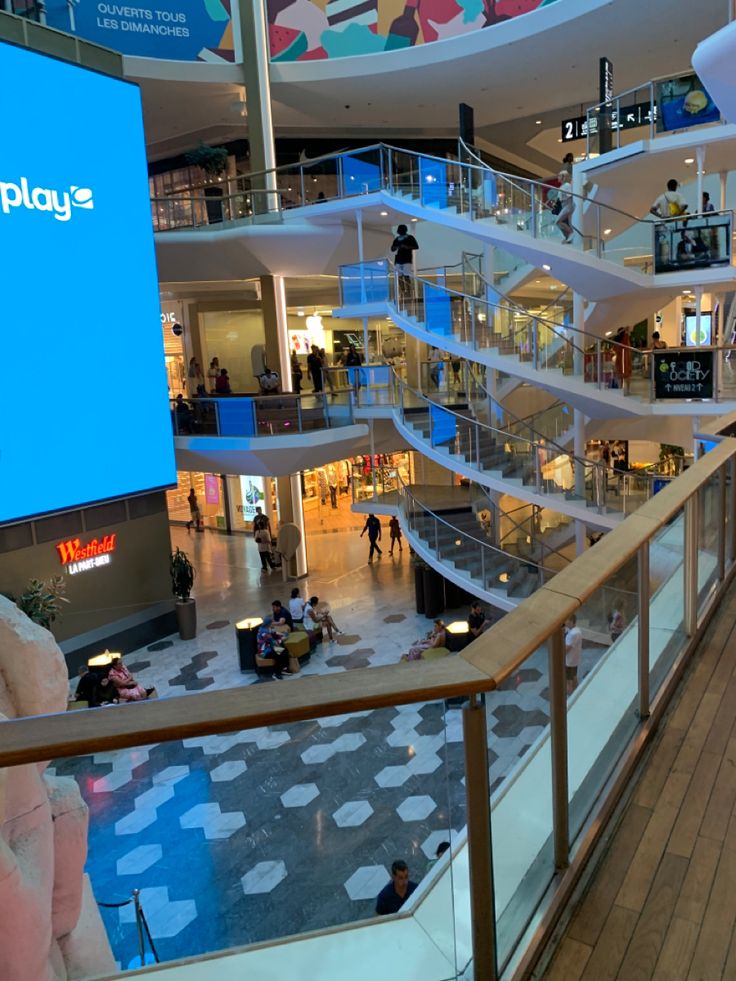 the inside of a shopping mall with people walking around