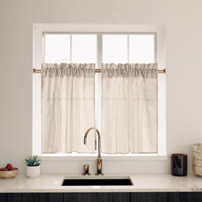 a kitchen sink sitting under a window next to a counter