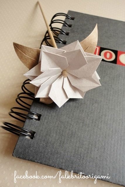 an origami flower on top of a notebook