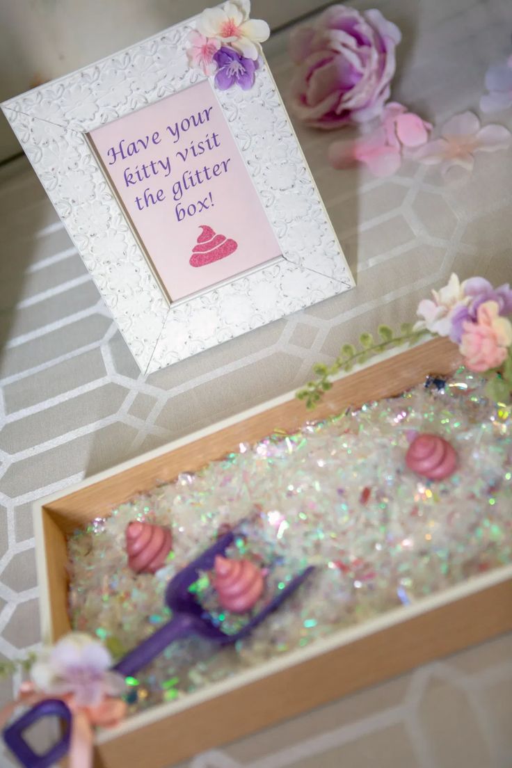 there is a card in a box with flowers on the table