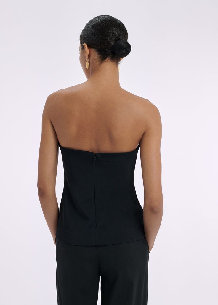 Strapless bustier top with interior boning detail, slim silhouette, and hip length for easy tucking. Details Strapless black bustier top Fitted silhouette Flexible boning Invisible back zip 97% Viscose 3% Elastane 1178MBND-ESSN Fits true to size. Take your normal size. Model is 5'10" and wears a size Small. Chic Tops With Built-in Bra And Fitted Bodice, Strapless Tops With Built-in Bra For Night Out, Chic Tube Top With Built-in Bra And Fitted Bodice, Stretch Tube Top With Built-in Bra For Evening, Sleeveless Evening Tops With Built-in Bra, Bandeau Tube Top With Fitted Bodice For Night Out, Fitted Bodice Bandeau Tube Top For Night Out, Evening Halter Top With Built-in Bra, Evening Backless Top With Built-in Bra