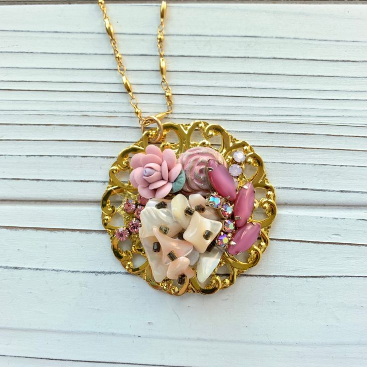 Thoughtfully curated mosaic of vintage pieces creating a stunning and eye-catching handmade pendant in a soft blush color palette hung on 33-inch gold plated chain. Gorgeous vintage vibe! Only one of its kind! Makes a great gift or treat yourself! Thanks for looking! Pink Necklace With Large Pendant, Unique Pink Necklace With Large Pendant, Unique Pink Vintage Charm Jewelry, Unique Pink Jewelry With Vintage Charm, Unique Pink Pendant Necklace, Whimsical Gold Jewelry With Vintage Charm, Artisan Gold Jewelry With Vintage Charm, Pink Necklace With Large Round Pendant, Pink Bohemian Jewelry With Vintage Charm