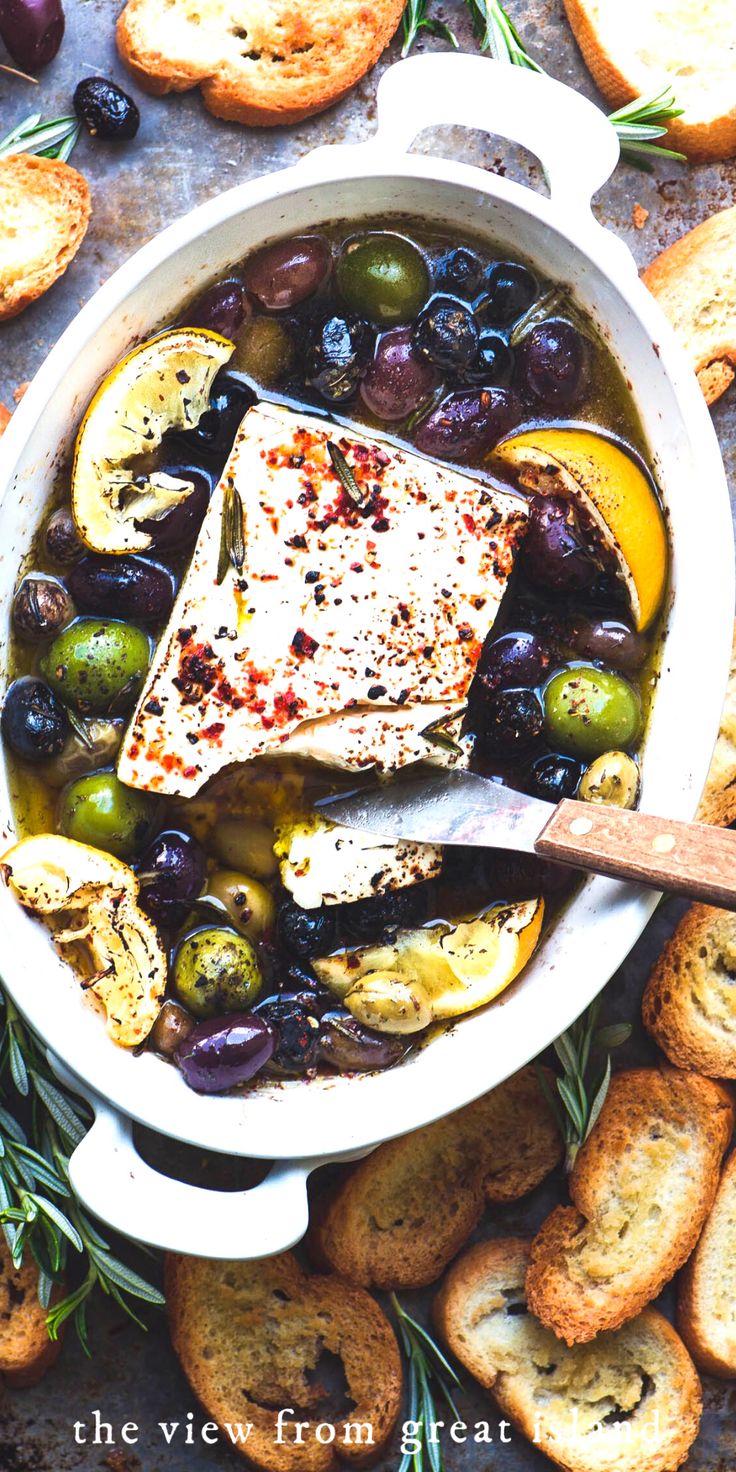 a pot filled with olives, bread and fish