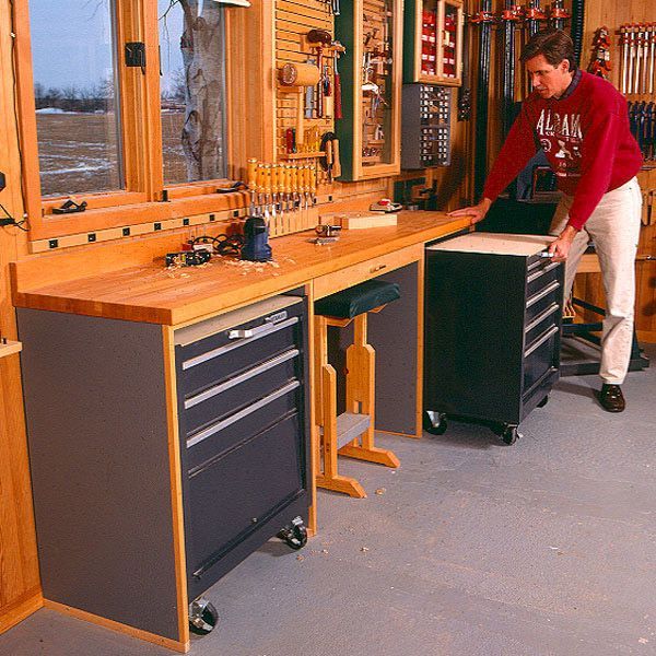 a man standing in front of a workbench with lots of tools on it