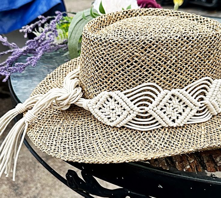 a straw hat sitting on top of a metal table next to flowers and other items