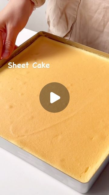 a person is holding a sheet cake in front of the screen and placing it on top of the pan