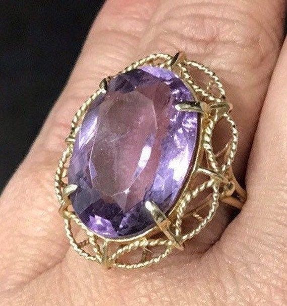 VINTAGE AMETHYST 14K YELLOW GOLD FILIGREE RING Unique and rare design, Fine Oval Amethyst Solitaire Ring approximately 15ct, set in a gorgeous filagree design band. There is a scratch/crack in back of stone. (see pics) Does not go through. It is not really visible from front, I've worn and never noticed until photographing now. Price reflects this. This item is vintage and beautiful that is sure to be one of your favorite pieces! Oval cut Amethyst totaling approximately 15 CTW! Measures approxim Fine Jewelry Oval Amethyst Gemstone Ring, Purple Oval 14k Gold Gemstone, Luxury Oval Yellow Gold Gemstones For Anniversary, Yellow Gold Oval Gemstone For Anniversary, Oval Yellow Gold Gemstones For Anniversary, Oval Amethyst Ring For Formal Occasions, Oval Amethyst Ring With Center Stone In Gold, Oval Gold Amethyst Ring With Center Stone, Oval Amethyst Ring With Center Stone