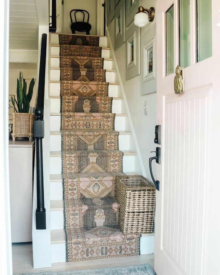 a stair case with rugs and baskets on the bottom, next to a door