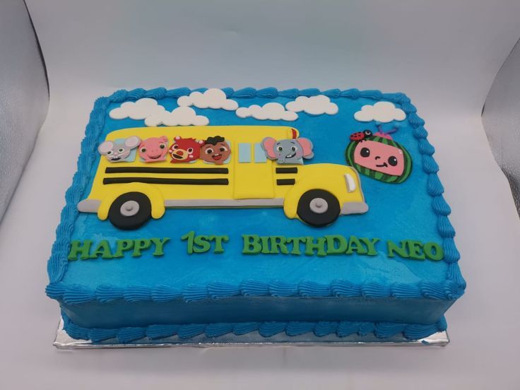 a blue and yellow birthday cake with three little pigs on it's side, in the shape of a school bus