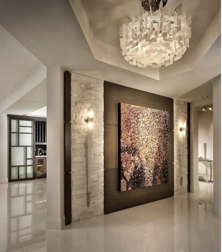 a large painting hanging on the wall next to a chandelier in a living room