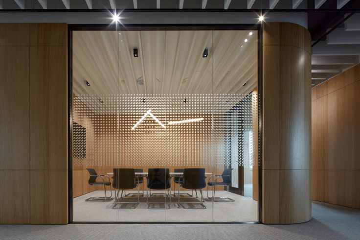 an empty meeting room with wooden walls and chairs