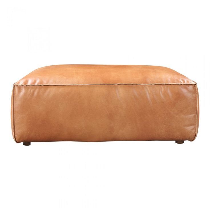 a tan leather ottoman sitting on top of a white floor