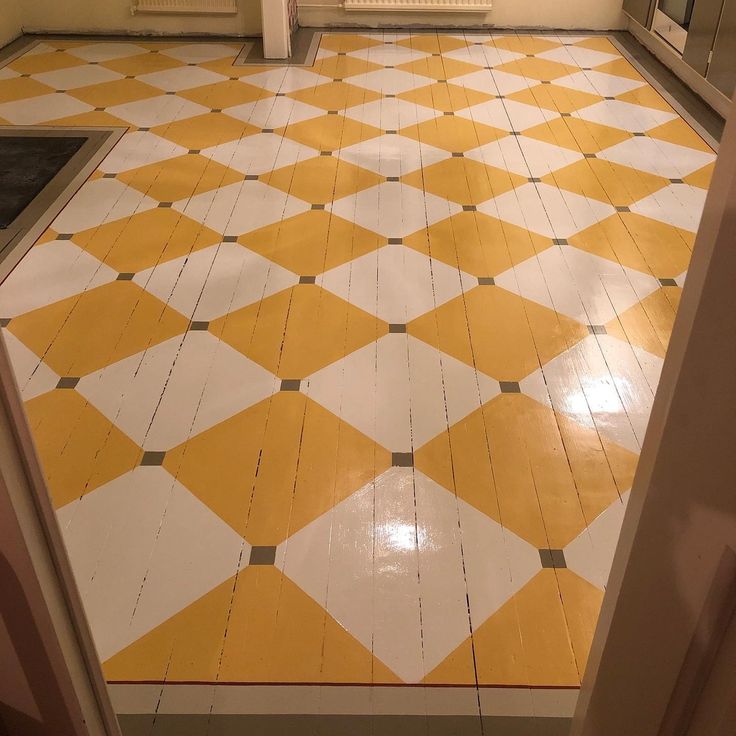 an orange and white tiled floor in a room with a door leading to another room