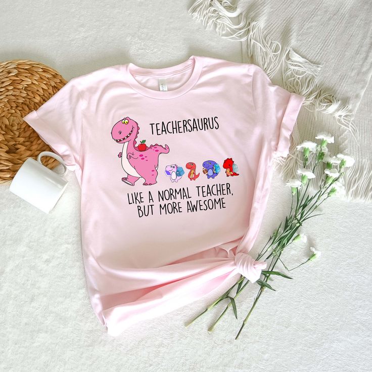 a pink t - shirt that says teacherssauruss like a normal teacher but more awesome